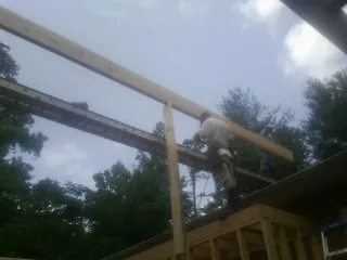Carpenter setting a ridge beam over a new addition frame — Ice Dam Removal by Roofing Brothers in Von Ormy