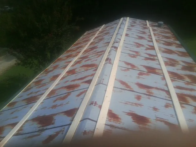 Rusted metal roof panels with new wood purlins before replacement — Storm Damage Roof Repair in Von Ormy by Roofing Brothers